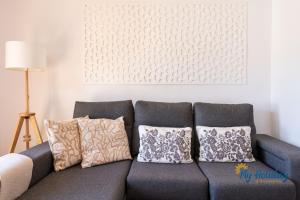 niebieska kanapa z poduszkami w salonie w obiekcie Duplex by Yumbo w mieście Playa del Ingles