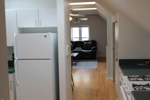 a kitchen with a white refrigerator and a living room at Lincoln Park Living - 3 Queen Beds - Sleeps 6 in Chicago