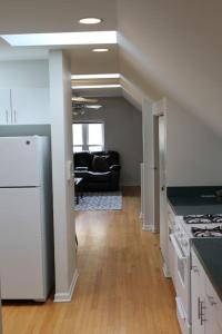 a kitchen with white appliances and a living room at Lincoln Park Living - 3 Queen Beds - Sleeps 6 in Chicago