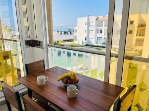 - un bol de fruits sur une table en bois sur un balcon dans l'établissement Escape-Vue sur mer, à Tanger