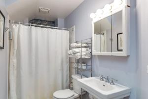 uma casa de banho com um WC, um lavatório e um espelho. em Lincoln Park Living - Suite 1 em Chicago