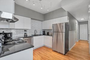 a kitchen with white cabinets and a stainless steel refrigerator at 713a - Settle in Historic Soulard in Soulard