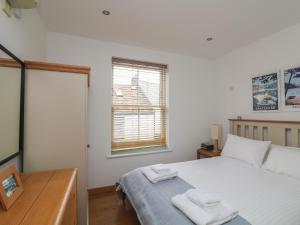 1 dormitorio con 1 cama con 2 toallas en Albatross, 3 Harbour Yard en Salcombe