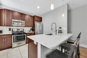 una cucina con piano di lavoro bianco e armadi in legno di Stunning Townhome 916 in The Grove a Tower Grove