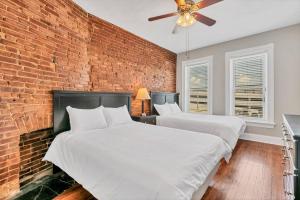 two beds in a room with a brick wall at St Louis Townhome-Perfect for Groups in Tower Grove