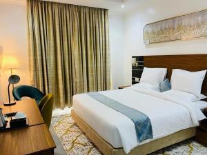um quarto de hotel com uma cama grande e uma secretária. em Randa Boutique Hotel em Kigali