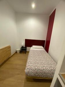 Un dormitorio con una cama y una mesa. en Hostal Abaaly, en Madrid