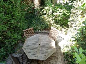 uma mesa de madeira com duas cadeiras num jardim em ambiance pub em Argenteuil