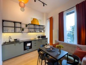 una cucina e un soggiorno con tavolo e sedie di URBAN APARTMENTS PREMIUM, Sokolska 30 Towers No 3, Free Parking, Gym & Sauna, Self Check-in a Katowice