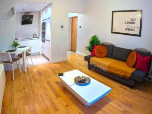 a living room with a couch and a table at Le Cwtch - Beautiful 1 bed boutique apartment in Cardiff