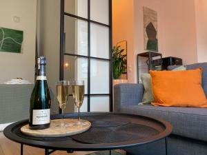 una bottiglia di vino e due bicchieri di champagne su un tavolo di URBAN APARTMENTS PREMIUM, Sokolska 30 Towers No 3, Free Parking, Gym & Sauna, Self Check-in a Katowice