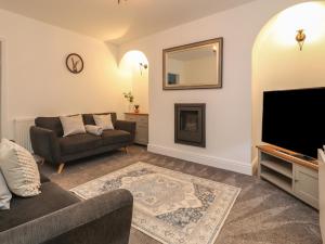 a living room with a couch and a flat screen tv at 10 Haw Grove in Skipton