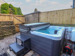 a hot tub in a backyard with a wooden fence at 10 Haw Grove in Skipton