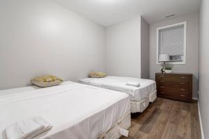 1 Schlafzimmer mit 2 Betten, einer Kommode und einem Fenster in der Unterkunft Suite 1 on Southport 4 Queen Beds in Chicago