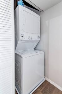 a refrigerator with a washer and dryer in a room at Suite 1 on Southport 4 Queen Beds in Chicago
