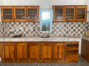 Una cocina con gabinetes de madera y un fregadero. en Choco Lush Villa, en Arugam Bay