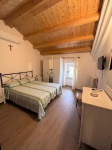 ein Schlafzimmer mit einem Bett und einer Holzdecke in der Unterkunft BILO MARIAGRAZIA in Marcelli