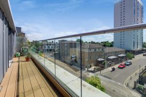 a balcony with a view of a street and buildings at Stay in Style: Modern 2-Bed In Trendy London Area in London