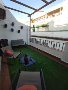 a room with a balcony with chairs and a table at Apartamento Barrionuevo in Córdoba