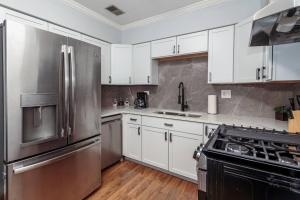 cocina con armarios blancos y nevera de acero inoxidable en MTM Fully Furnished Rental in Old Town - 2 Beds en Chicago