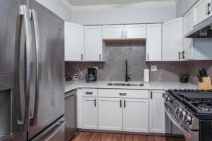 a kitchen with white cabinets and a stainless steel refrigerator at MTM Fully Furnished Rental in Old Town - 2 Beds in Chicago