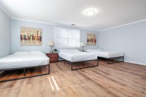 2 łóżka w pokoju z drewnianą podłogą w obiekcie Beautiful Remodeled Penthouse Unit in Old Town w Chicago