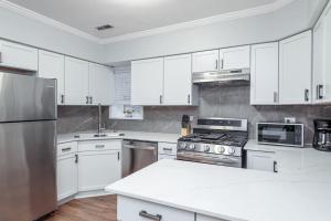 uma cozinha com armários brancos e electrodomésticos brancos em Beautiful Remodeled Penthouse Unit in Old Town em Chicago