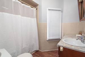 シカゴにあるBeautiful Remodeled Penthouse Unit in Old Townのバスルーム(白いシャワーカーテン、シンク付)
