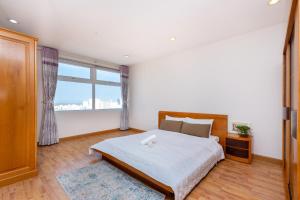 een slaapkamer met een bed en een groot raam bij Silver Sea Tower in Vung Tau