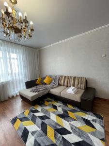 a living room with a couch and a rug at 1 комнатная Таттимбета 5 (Юго-Восток) in Karagandy