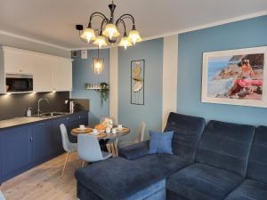 a living room with a couch and a table at Sun Towers EXspanse apartament 3 pokoje z parkingiem i tarasem in Świnoujście