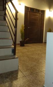 a hallway with a staircase and a door with a potted plant at Apartamento cómodo in Potosí