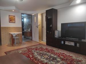 ein Wohnzimmer mit einem Flachbild-TV und einem Teppich in der Unterkunft POKÓJ MERY in Augustów