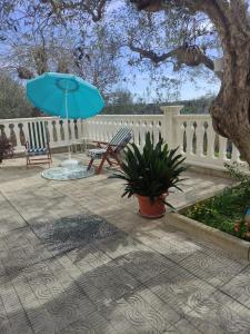 Casa vacanze l'Ulivo في روكا سان جوفاني: حاجز مع كرسي ومظلة زرقاء