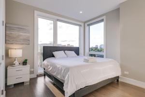 a white bedroom with a large bed and windows at New Construction Building in River North in Chicago