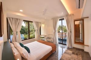Postel nebo postele na pokoji v ubytování Lembranca Studios & Suites Near Famous FLOATING CASINOS of Goa