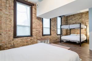 a bedroom with a bed and a brick wall at Beautifully Remodeled Flat Downtown # 2N in Chicago