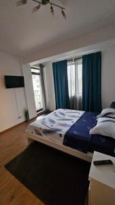 a bedroom with a bed with blue sheets and a window at Doxa Airport Otopeni in Otopeni +20 photos