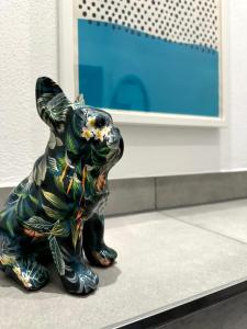 uma estátua de um cão sentado em frente a uma parede em casa ECH Ferienhaus Oberelsbach em Oberelsbach