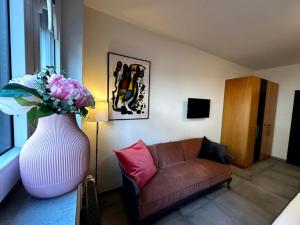 ein Wohnzimmer mit einem Sofa und einer Vase mit Blumen in der Unterkunft casa ECH Ferienhaus Oberelsbach in Oberelsbach