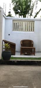 dos bancos sentados frente a una pared blanca en Jambo hostel tz en Dar es Salaam