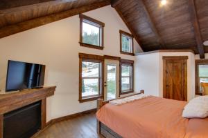 a bedroom with a bed and a flat screen tv at Dazzling Cle Elum Home with Game Room and Fire Pit! in Ronald