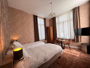 デ・ハーンにあるHotel Canteklaarのベッドとデスクが備わるホテルルームです。