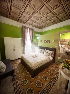 1 dormitorio con 1 cama grande en una habitación con paredes verdes en Lesuite en Nápoles