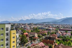 a city with buildings and mountains in the background at Blue Moon Apartments in Braşov