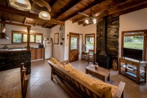 a living room with a couch and a tv and a kitchen at la candelaria in Tandil