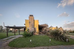 un edificio amarillo con una torre en un parque en la candelaria en Tandil