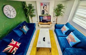 a living room with a blue couch and a tv at 6 Bedroom House -Sleeps 12- Big Savings on Long Stays!! in Ipswich