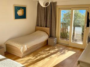 a bedroom with a bed and a large window at EnjoyIseoLake - Corinto - wonderful Lake front apartment in Parzanica +13 photos