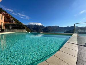 a swimming pool with mountains in the background at EnjoyIseoLake - Corinto - wonderful Lake front apartment in Parzanica